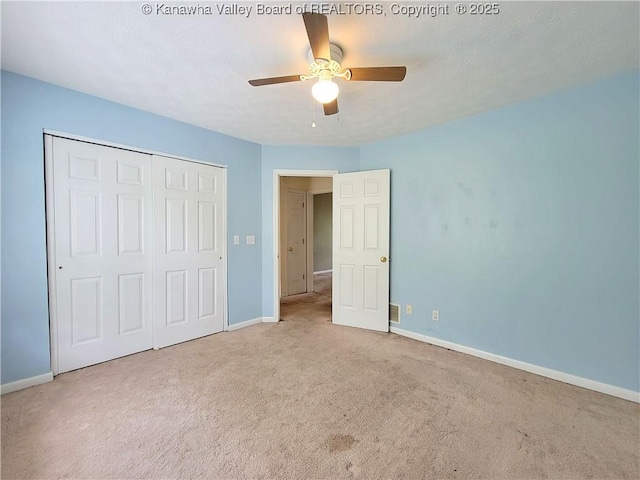 unfurnished bedroom featuring carpet floors, baseboards, a ceiling fan, and a closet