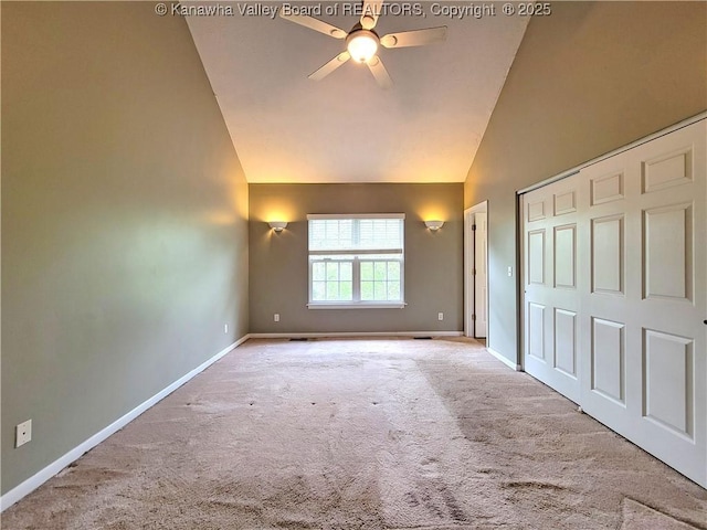 unfurnished bedroom featuring baseboards, carpet, a closet, and high vaulted ceiling