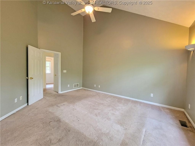 carpeted empty room with high vaulted ceiling, ceiling fan, baseboards, and visible vents