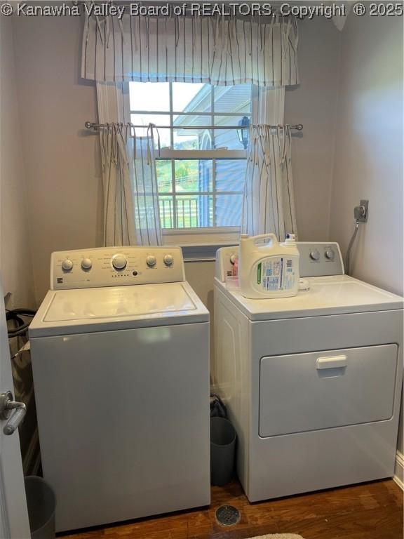 washroom with laundry area, washer and clothes dryer, and dark wood finished floors