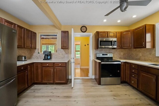 kitchen with light countertops, appliances with stainless steel finishes, tasteful backsplash, and a ceiling fan