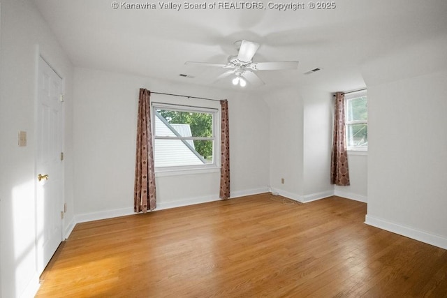 unfurnished room with a ceiling fan, baseboards, visible vents, and light wood-type flooring