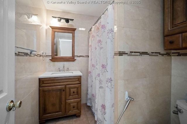 bathroom featuring vanity, tile patterned flooring, curtained shower, toilet, and tile walls