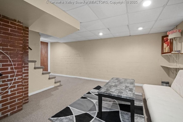interior space featuring recessed lighting, baseboards, a paneled ceiling, and brick wall