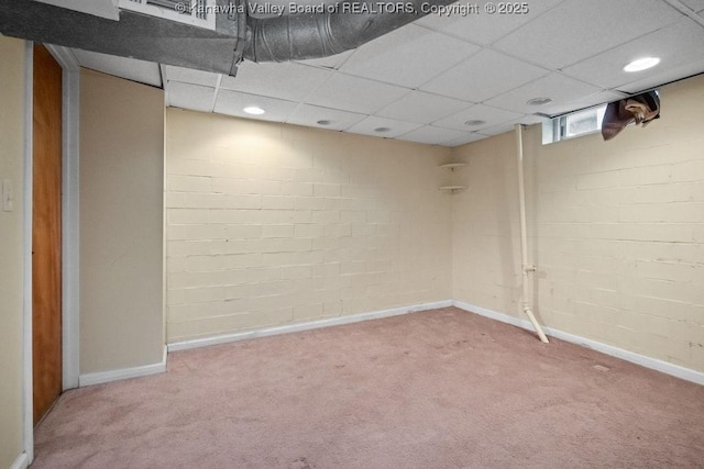 basement with baseboards, carpet, and a drop ceiling
