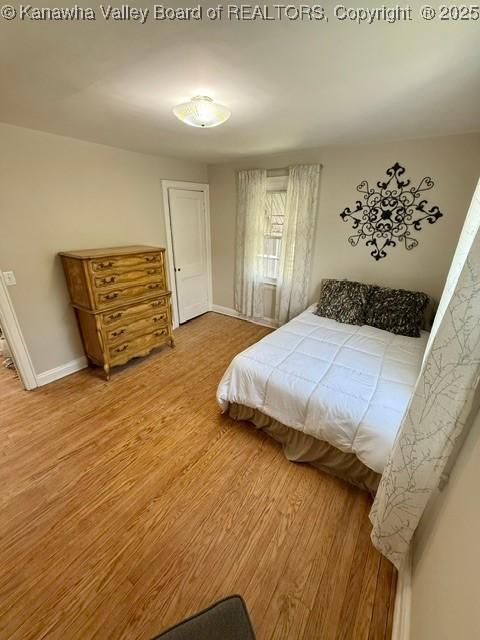 bedroom featuring baseboards and wood finished floors