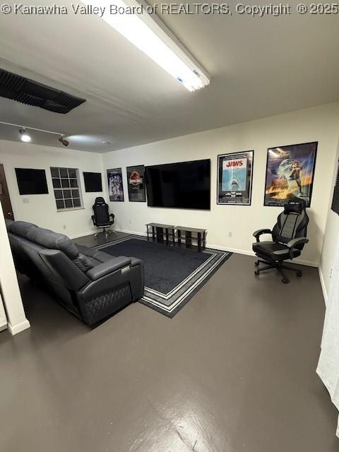 living room with baseboards and concrete flooring