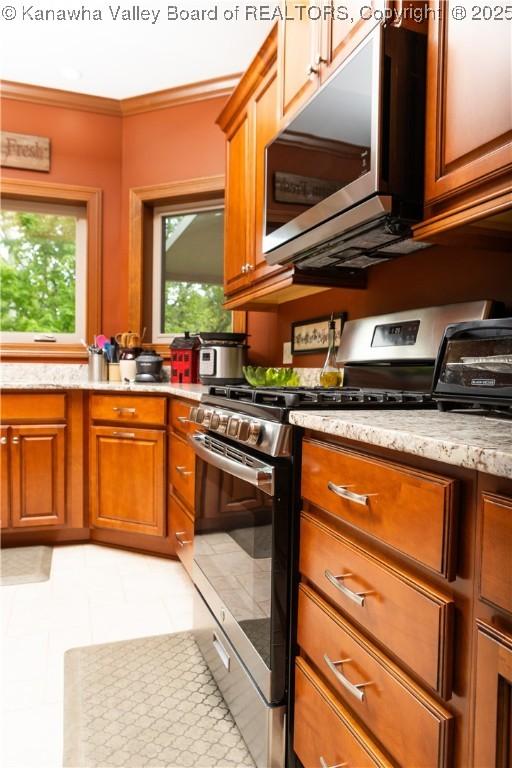 2804 Hash Ridge Rd, Barboursville, WV 25504 - kitchen with brown cabinets, appliances with stainless steel finishes, light stone counters, light tile patterned floors, and ornamental molding