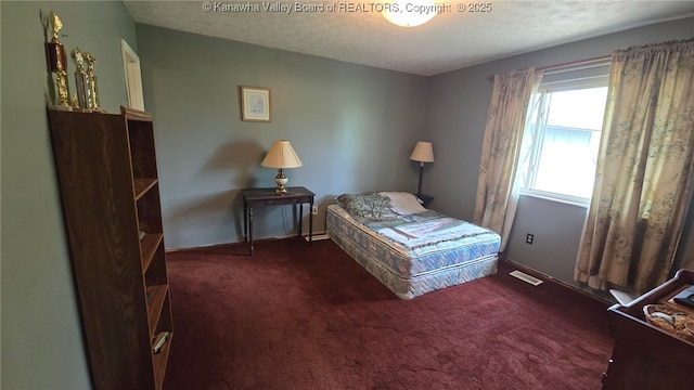 carpeted bedroom with a textured ceiling and visible vents
