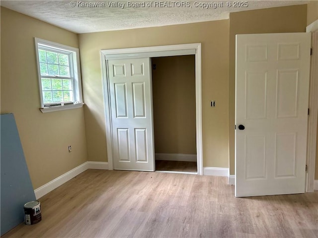 405 Crestview Dr, Charleston, WV 25302 - unfurnished bedroom featuring a textured ceiling, baseboards, a closet, and light wood-style flooring