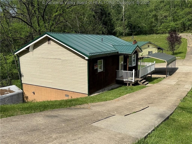 view of side of property with a porch, crawl space, and metal roof