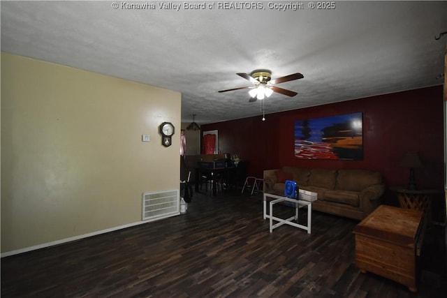 living room featuring visible vents, a ceiling fan, baseboards, and wood finished floors