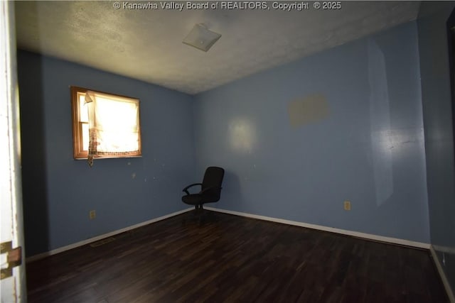 unfurnished room with baseboards and wood finished floors
