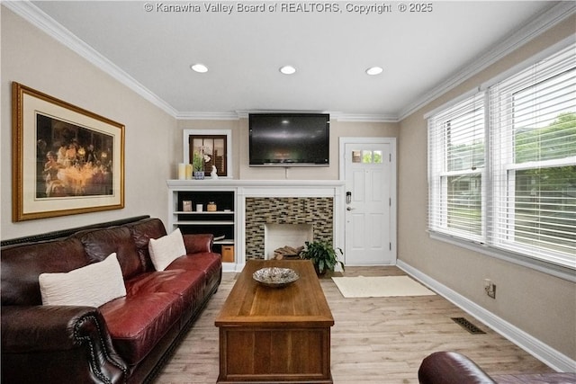 315 27th St SE, Charleston, WV 25304 - living room featuring a tile fireplace, light wood-style floors, ornamental molding, and recessed lighting