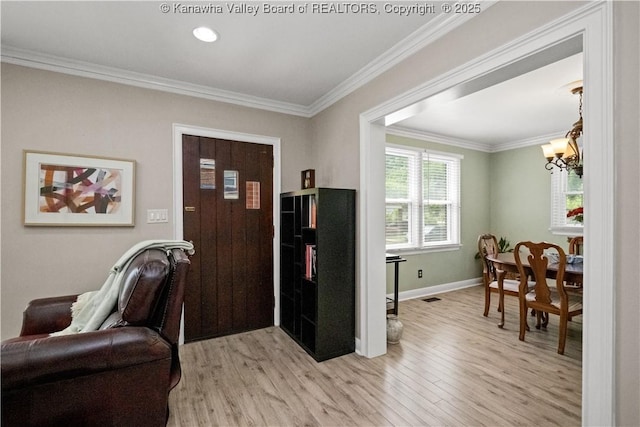 315 27th St SE, Charleston, WV 25304 - entrance foyer with an inviting chandelier, crown molding, baseboards, and light wood-type flooring