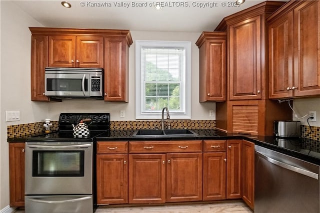 315 27th St SE, Charleston, WV 25304 - kitchen featuring dark countertops, appliances with stainless steel finishes, brown cabinets, and a sink