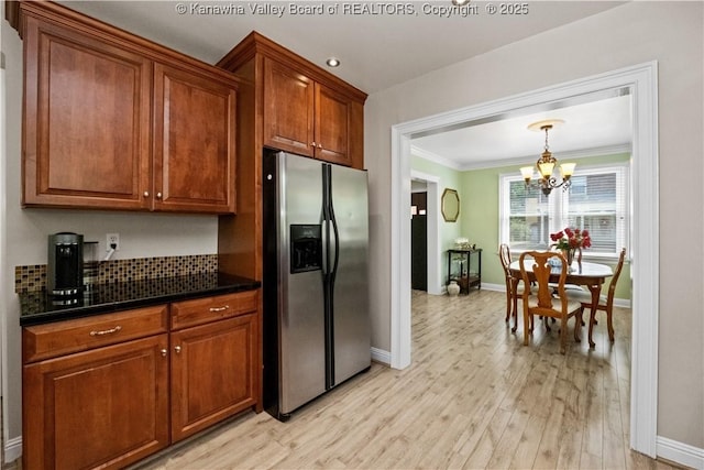 315 27th St SE, Charleston, WV 25304 - kitchen with baseboards, crown molding, stainless steel fridge, a notable chandelier, and dark countertops
