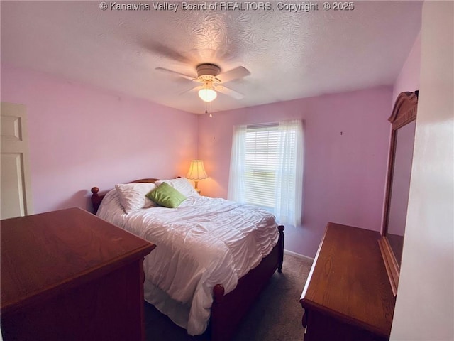 bedroom with ceiling fan, dark colored carpet, a textured ceiling, and baseboards