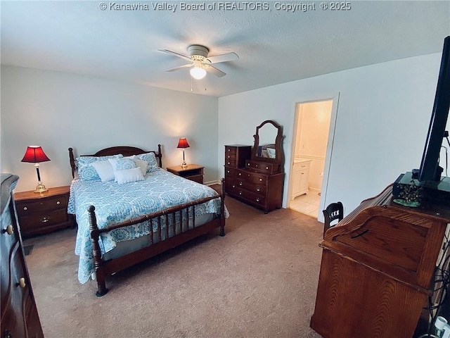 carpeted bedroom with ensuite bath, baseboards, and ceiling fan