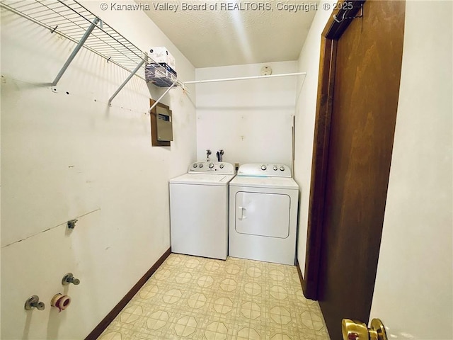 clothes washing area featuring laundry area, light floors, baseboards, and washing machine and dryer