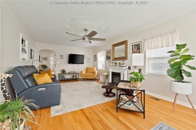 2258 Curtis Ave, Saint Albans, WV 25177 - living area with baseboards, a glass covered fireplace, ceiling fan, wood finished floors, and arched walkways