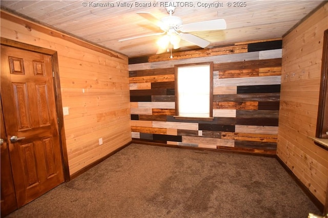unfurnished room featuring wood walls, wood ceiling, carpet floors, and a ceiling fan