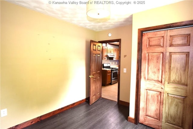 corridor with baseboards and dark wood-style floors