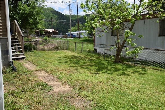 view of yard featuring a fenced backyard and stairs