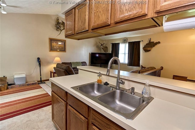 433 Kingswood Dr, Culloden, WV 25510 - kitchen with brown cabinetry, ceiling fan, a sink, open floor plan, and light countertops