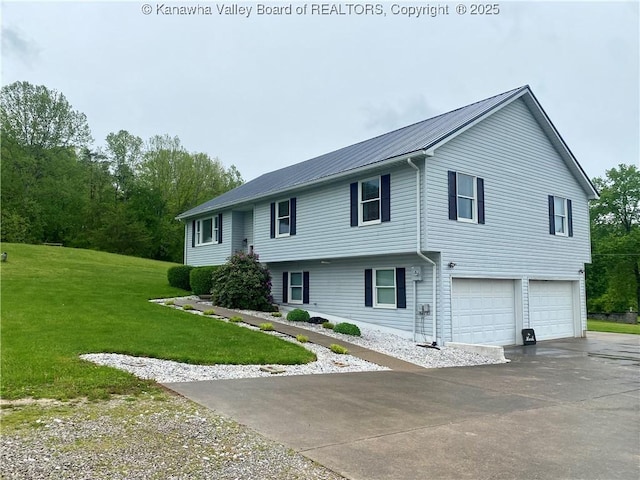 split foyer home featuring metal roof, a garage, a front lawn, and driveway