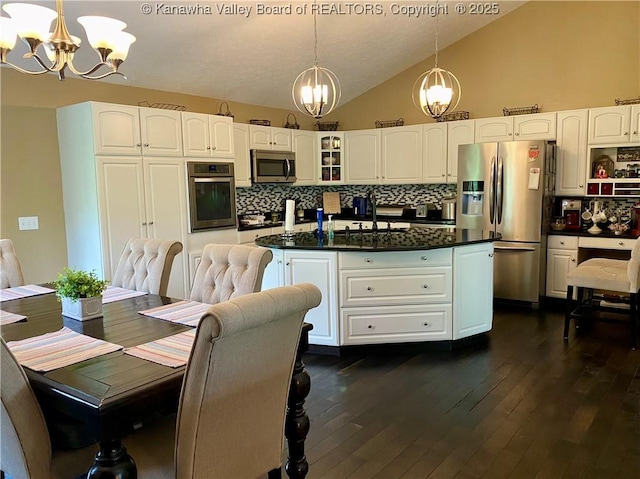 kitchen with stainless steel appliances, a notable chandelier, and decorative backsplash