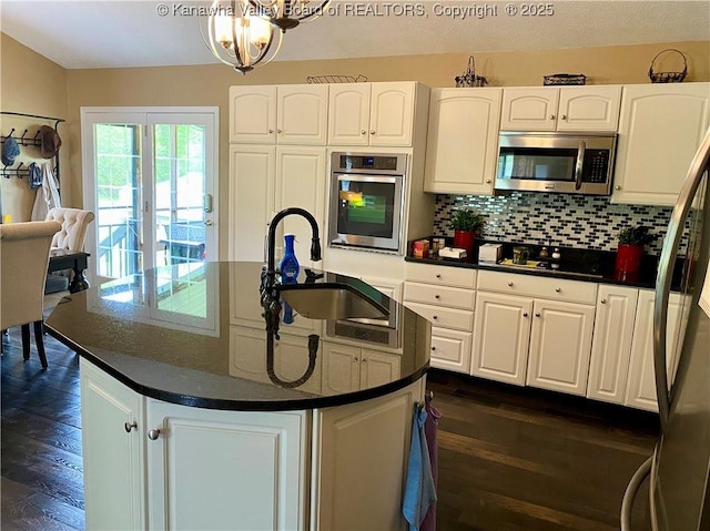 kitchen featuring a sink, white cabinetry, dark countertops, appliances with stainless steel finishes, and dark wood-style floors