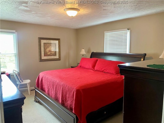 bedroom with light carpet and a textured ceiling