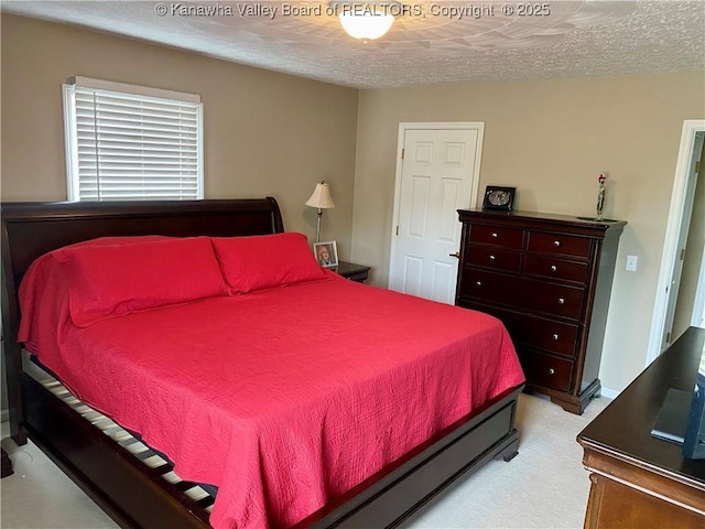 bedroom with a textured ceiling and light carpet