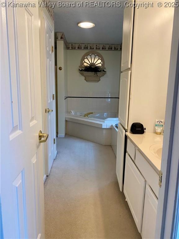 full bathroom with vanity and a tub to relax in