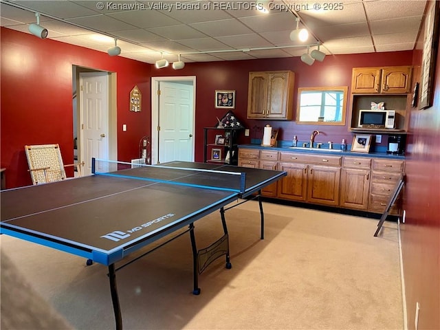 game room with rail lighting, light carpet, and a sink