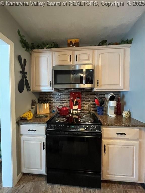 kitchen featuring stainless steel microwave, dark stone countertops, black electric range, backsplash, and white cabinets
