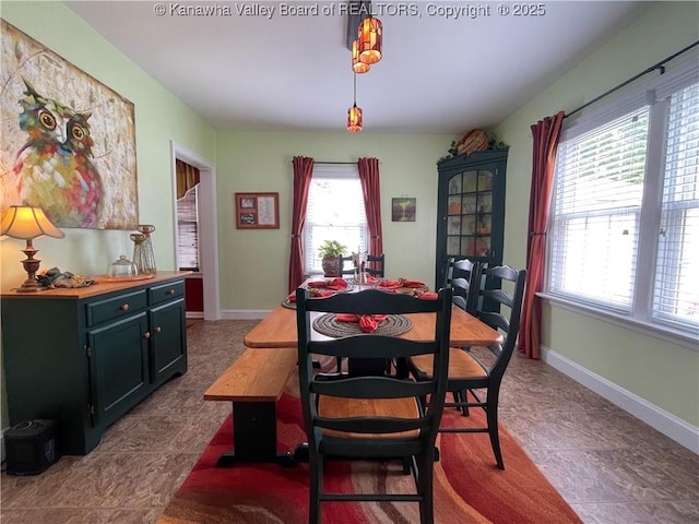 dining space with dark tile patterned flooring and baseboards