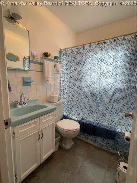 full bath with tile walls, toilet, tile patterned floors, vanity, and shower / bath combo