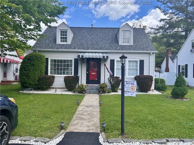cape cod home with roof with shingles and a front lawn