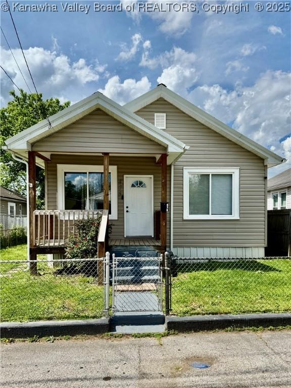 bungalow-style house with a porch, a front lawn, a gate, and a fenced front yard