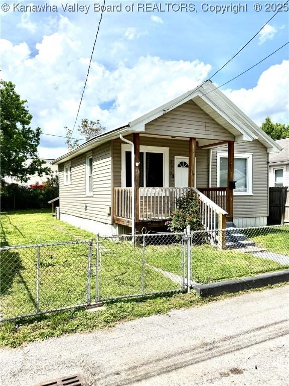 view of front of house with a porch, a fenced front yard, a gate, and a front yard