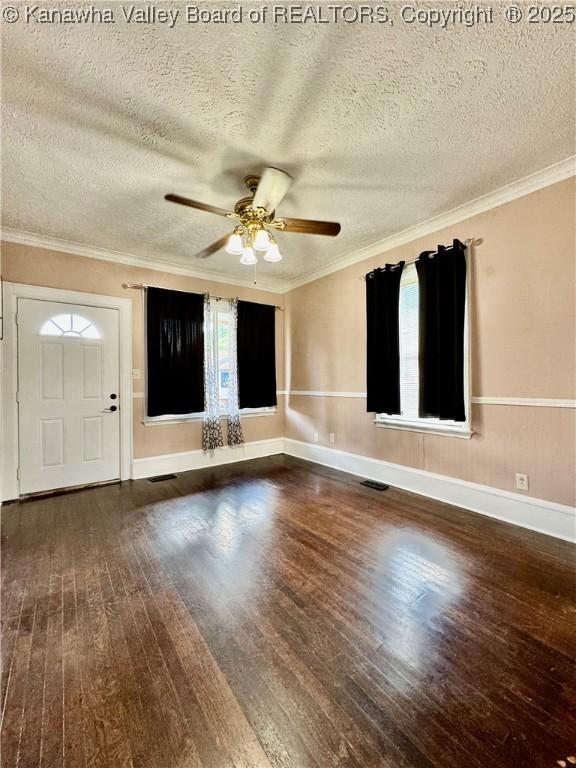 interior space with a ceiling fan, ornamental molding, a textured ceiling, and wood finished floors