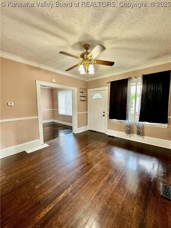 unfurnished living room featuring a textured ceiling, a wealth of natural light, a ceiling fan, and dark wood-style floors