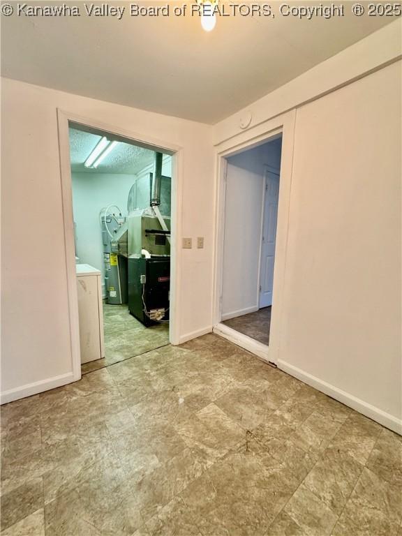 unfurnished room with electric water heater and baseboards