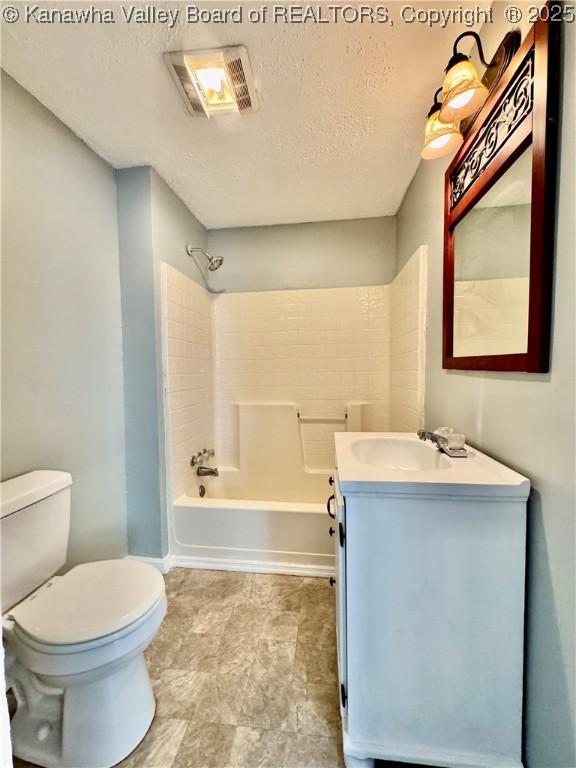 full bathroom featuring toilet, vanity, shower / tub combination, and a textured ceiling