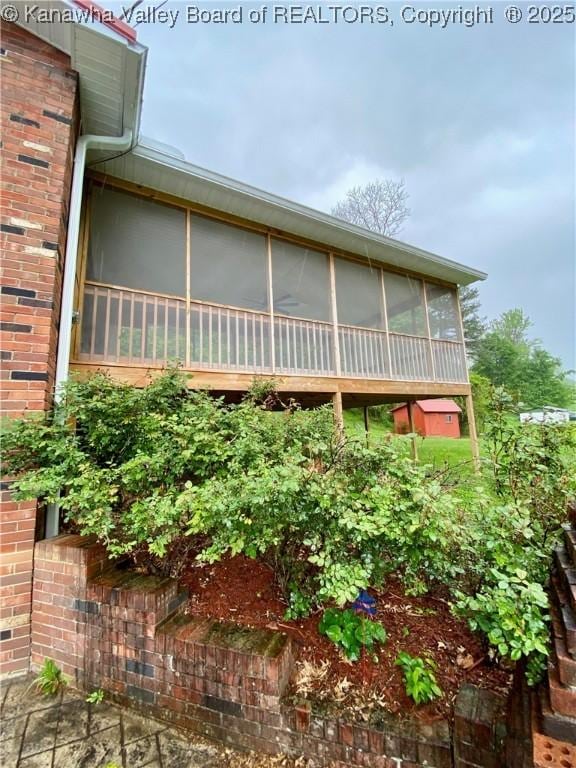 view of side of home with a sunroom and brick siding