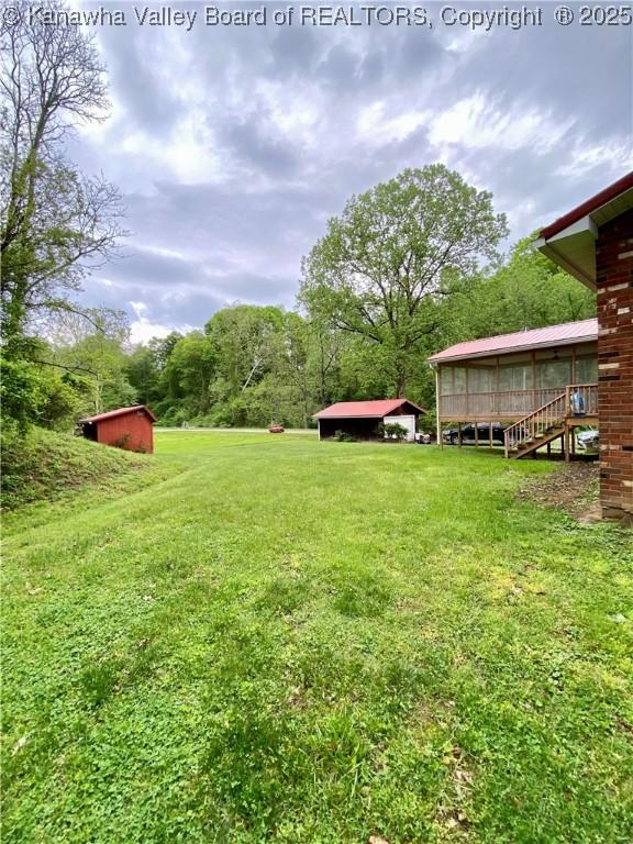view of yard with a storage shed, a sunroom, and an outdoor structure