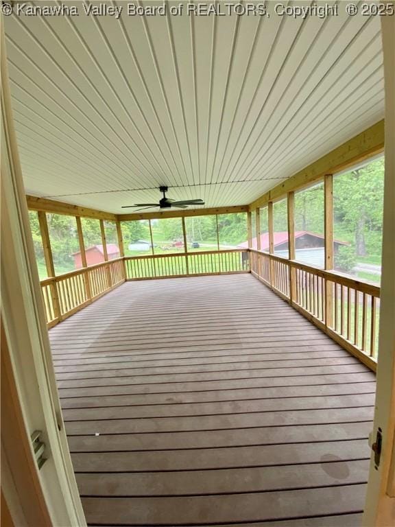 unfurnished sunroom featuring a ceiling fan