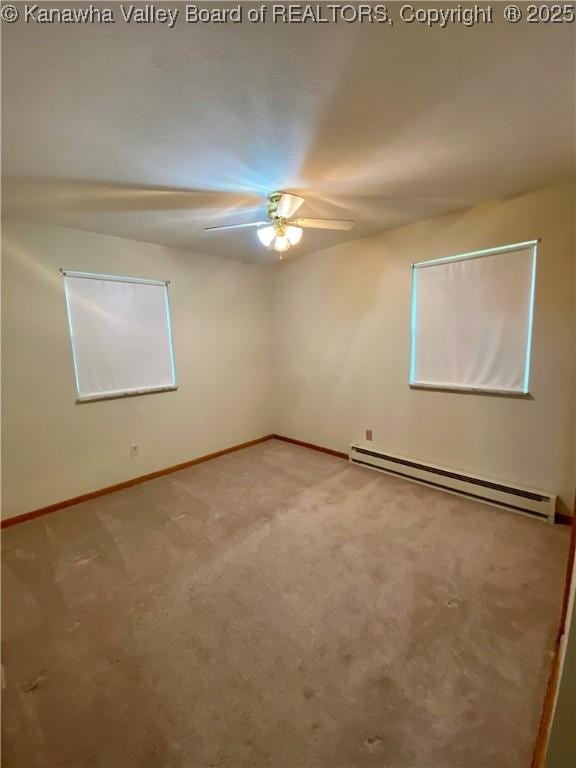 carpeted empty room with baseboards, a ceiling fan, and baseboard heating